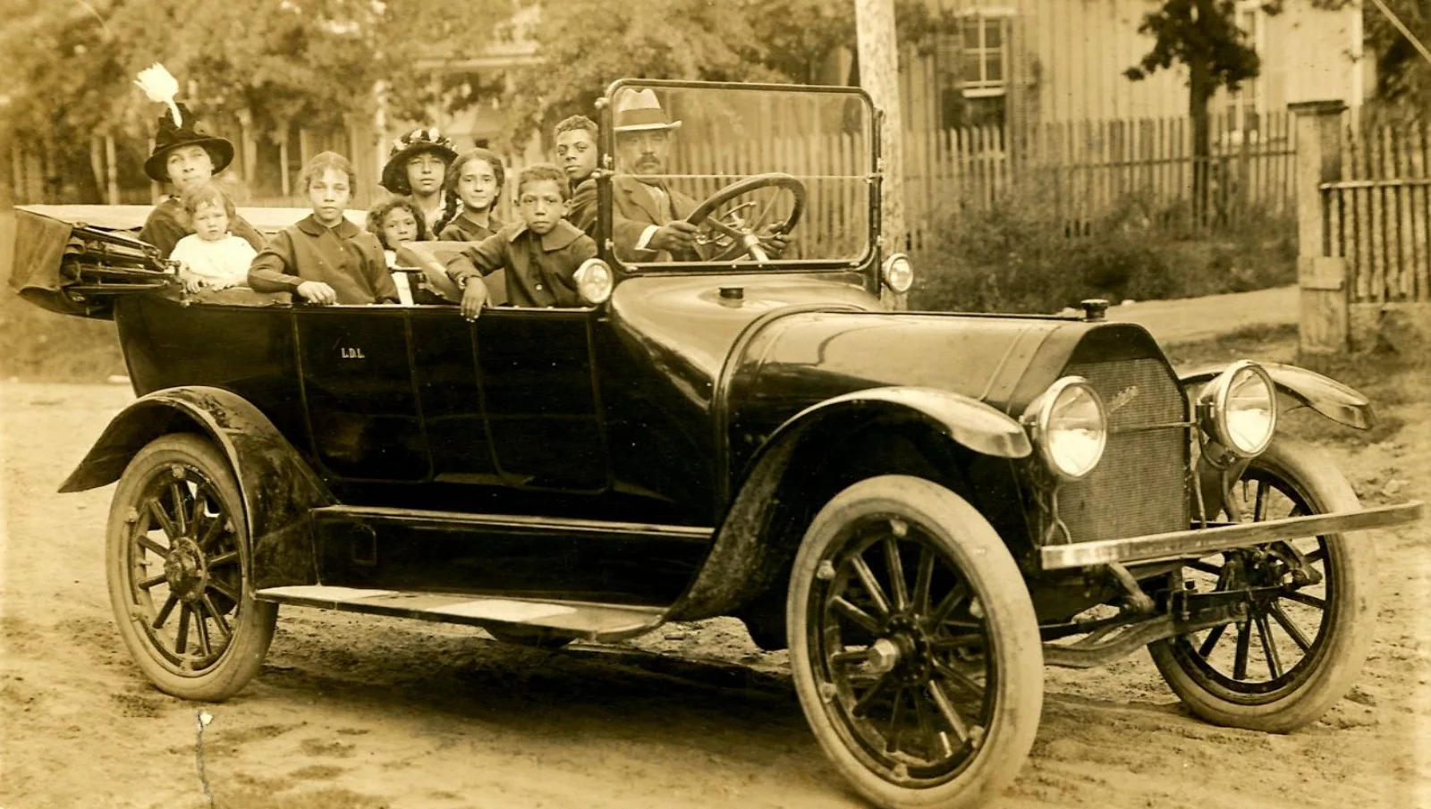 The Lyons family in their car, 1913. From L-R and relation to Eunice: Eva Sybil Carrington Lyons (mother), Eva Gwendolyn Lyons (sister), Eunice Lavinia Lyons, Emma A. Lyons (sister), Louise Lyons (sister), Maxine Moore (cousin), Woodward Cecil “Joe” Lyons (brother), Wendell C “Big Brother” Lyons (brother), L.D. Lyons (father).