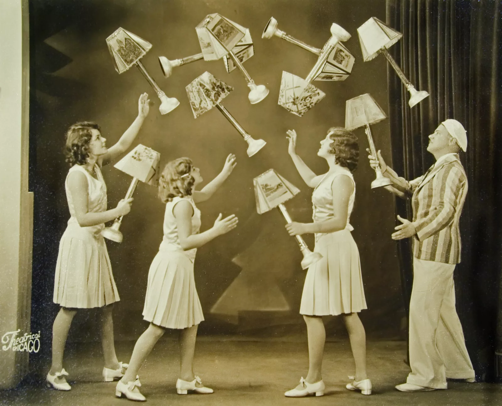 Four members of the Clarke Family juggle several lamps with shades.