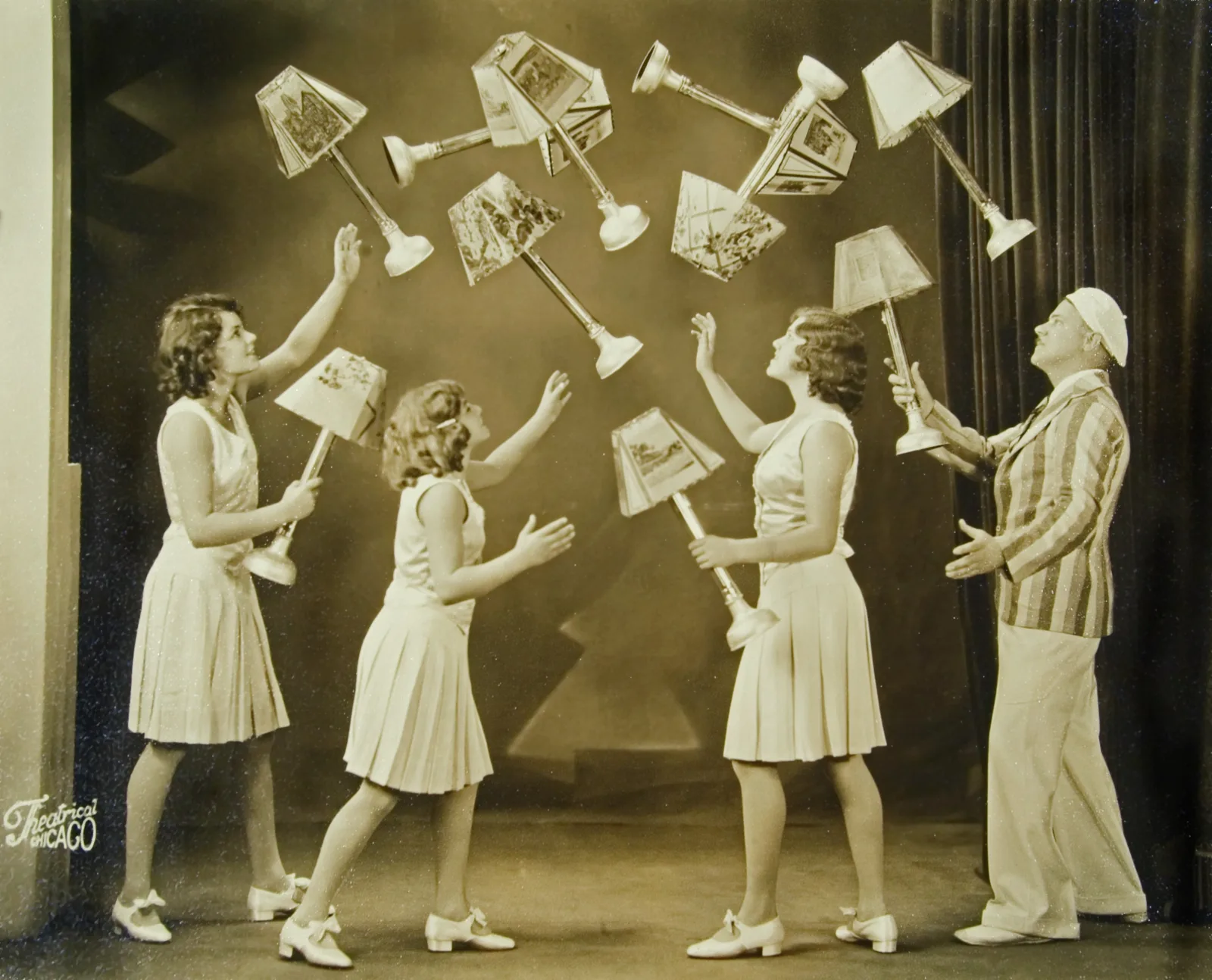 The Clarke Family Juggling Four members of the Clarke Family juggle several lamps with shades.