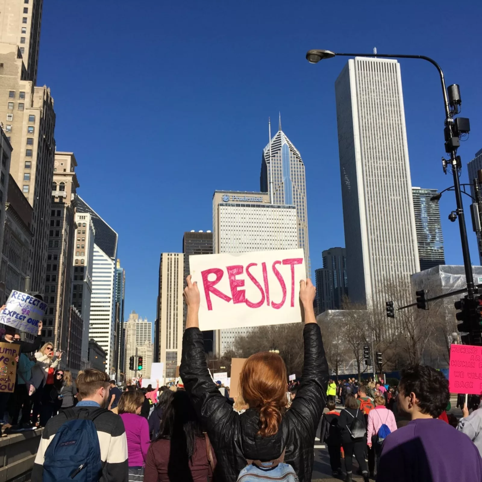 Protester holding a sign that reads "RESIST"