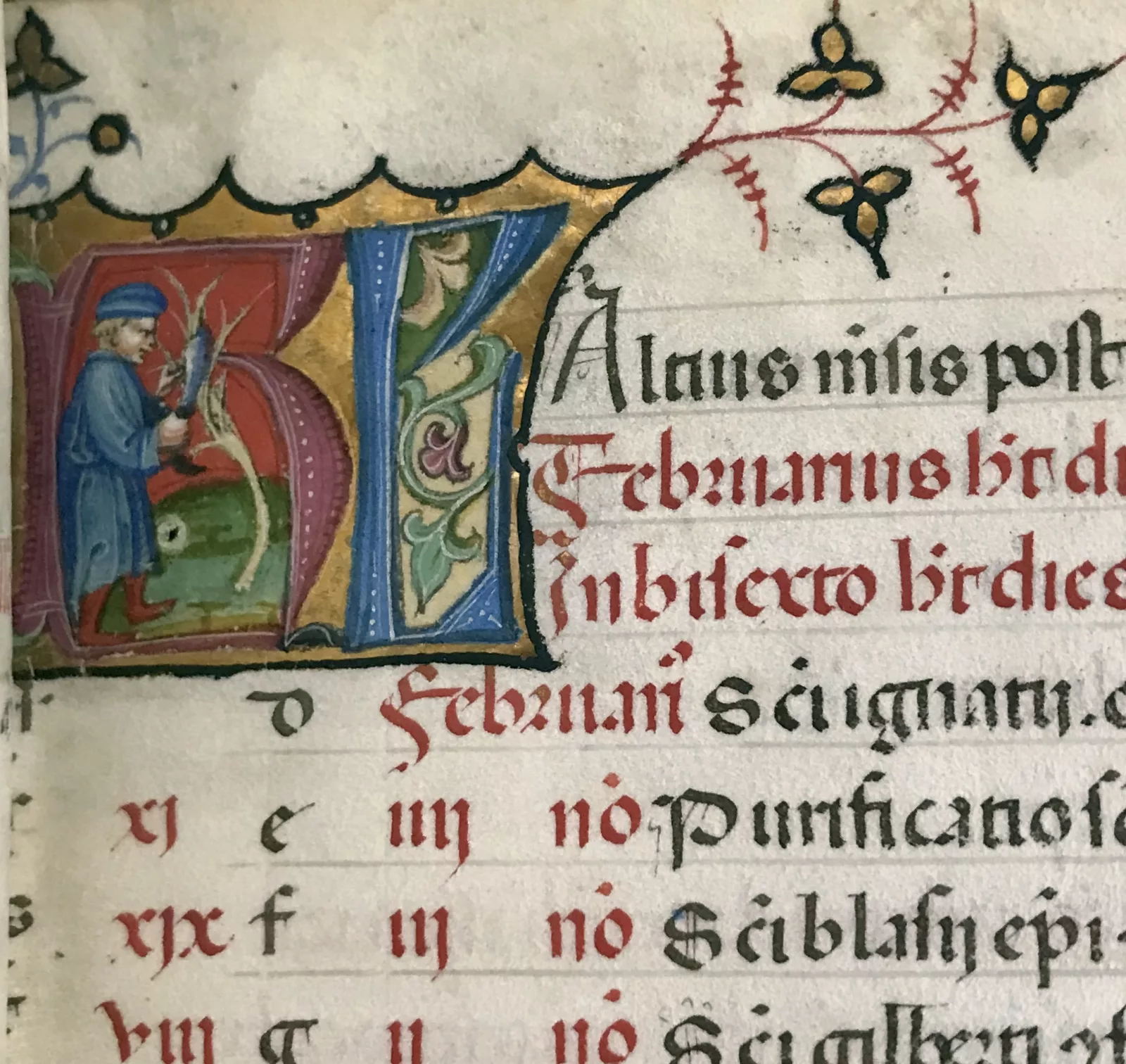 An illuminated initial depicts the act of pruning trees that was associated with the month of February.