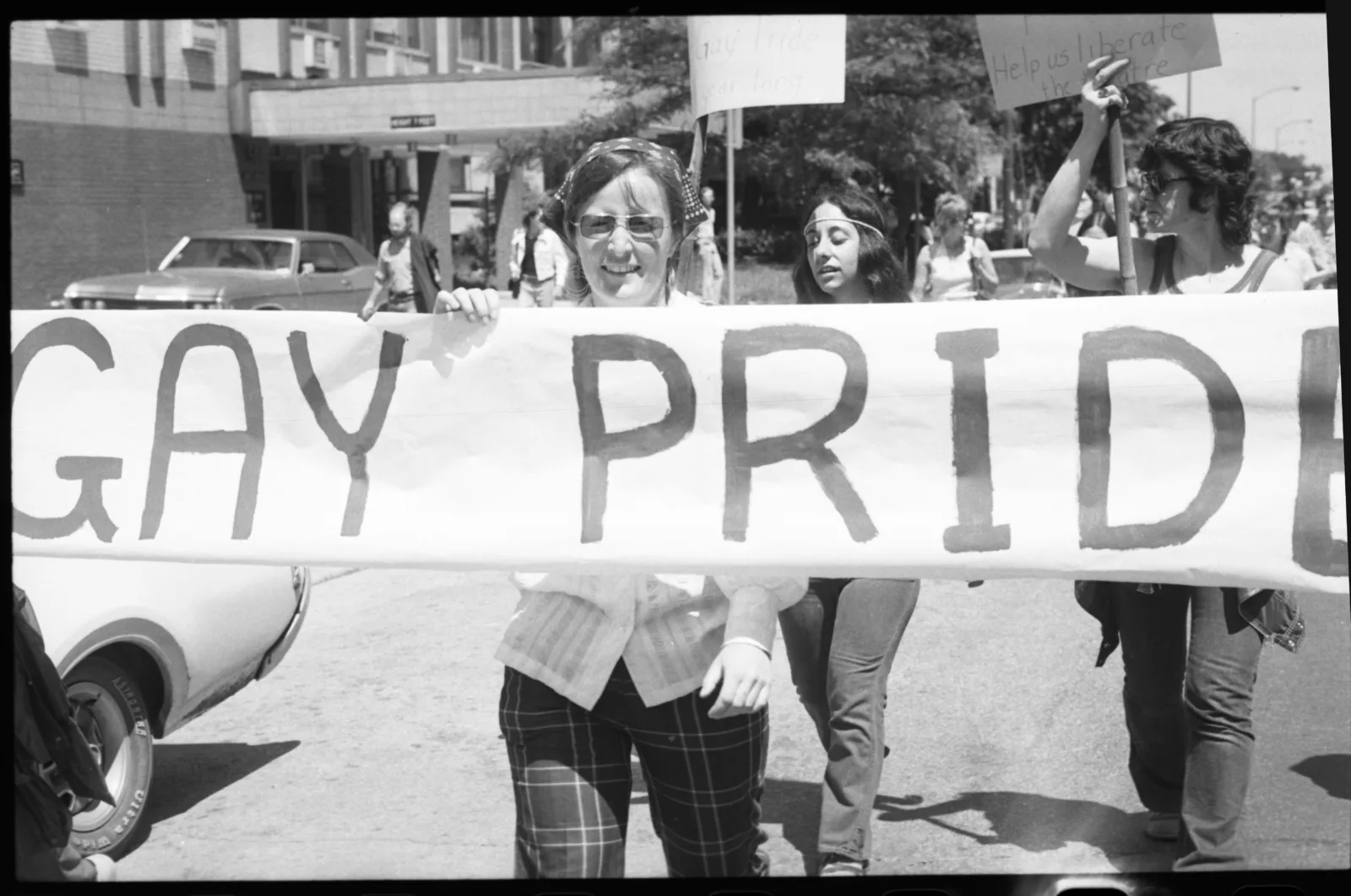 A woman holding a sign that says "Gay Pride"