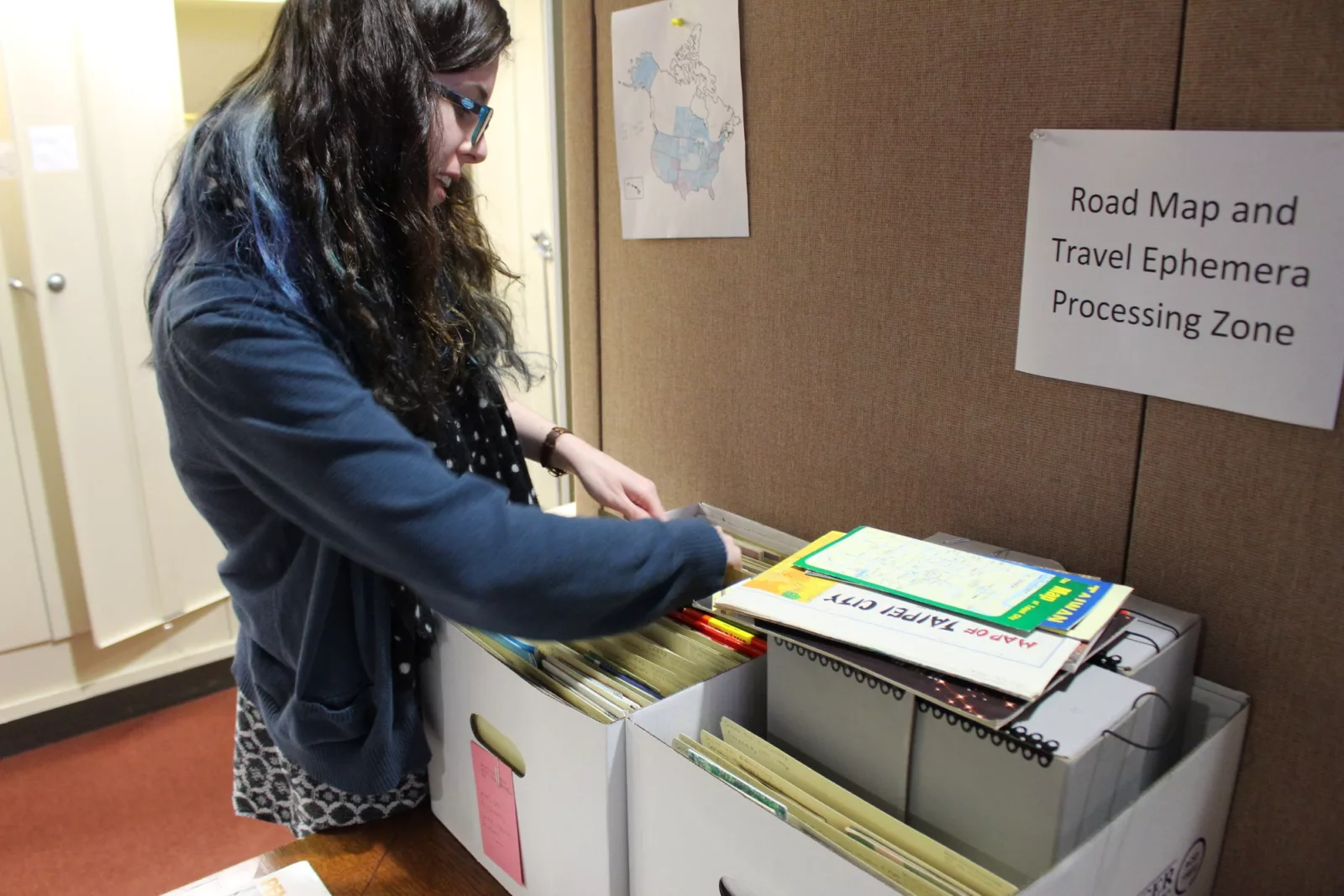 Processing Assistant Emily Richardson at work in the "Road Map and Travel Ephemera Processing Zone"