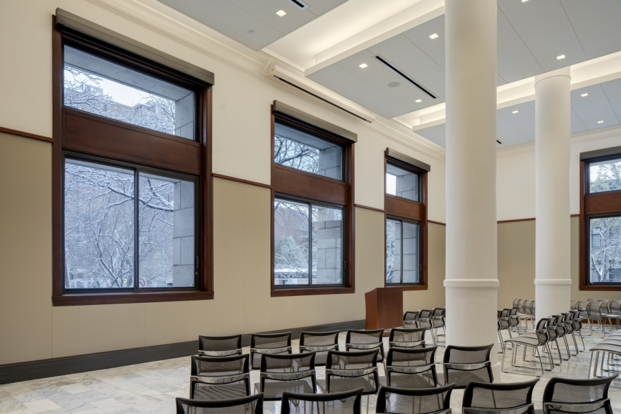 Rettinger Hall set up with lecture-style seating. A podium is at the front. Behind the podium are three large windows.